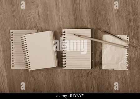 Crumpled empty pages and notebook lying on wooden surface Stock Photo