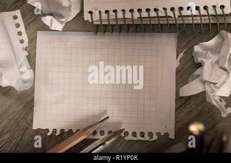 Empty crumpled pages and notebook lying on wooden surface Stock Photo