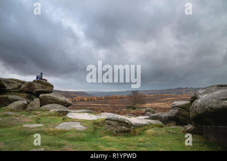 Hikers resting atop Owler Tor in Peak District during Autumn Fall afternoon Stock Photo