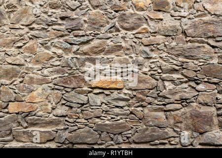 Old stone wall from the 17th century made from mixed size and color pieces Stock Photo