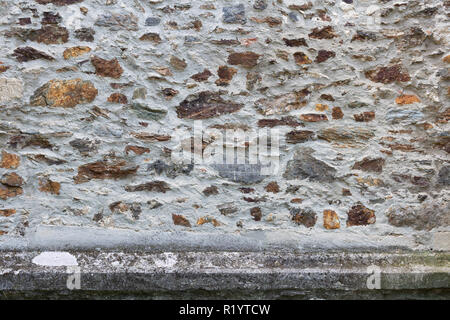 Old stone wall from the 17th century made from mixed size and color pieces Stock Photo