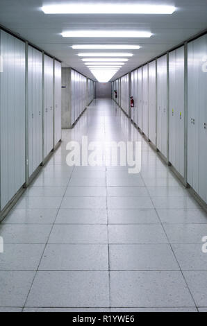 Illuminated empty corridor hallway bright neon lights symmetrical Stock Photo