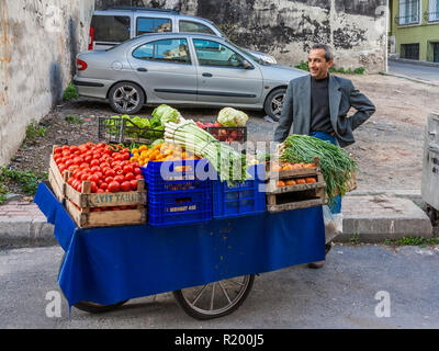 Istanbul, Turkey, November 13, 2012: Turkish man selling vegetables from a barrow. Stock Photo