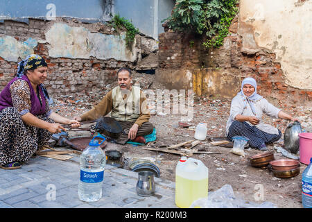 Istanbul, Turkey, November 13, 2012: Tinkers tinning pots in the street in the Balat District. Stock Photo