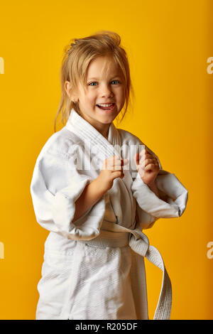 Adorable girl in kimono on yellow background Stock Photo