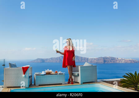 Young woman having Breakfast by the sea in Greece