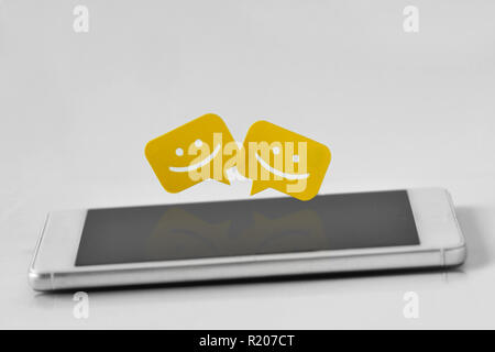 Smartphone with chat message bubbles on white background Stock Photo