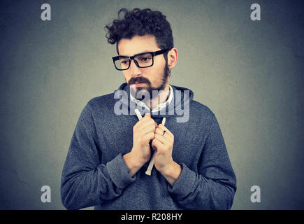 Young bearded man pointing feeling shy and guilty in awkward situation Stock Photo