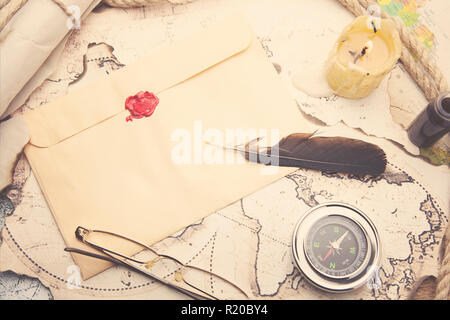 Old feather, envelope, sealing wax on the map Stock Photo