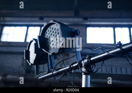 Theater spotlights on black industrial room with windows. Stock Photo