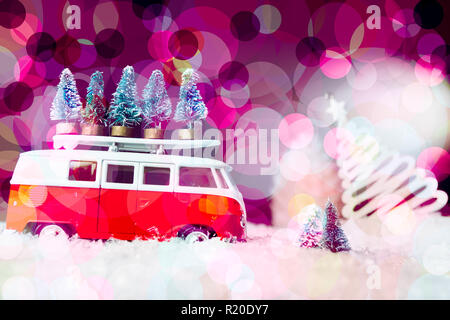 Christmas travel concept for holiday, a van transport little christmas tree in the snow with   christmas decoration and gorgeus bolelicious ackground Stock Photo