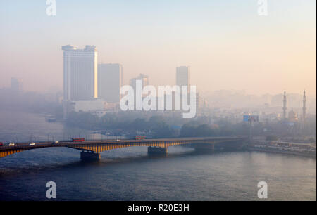 Cairo in Smog: smoggy view of Cairo University Bridge from Giza to Cairo over the River Nile, skyscrapers, Hyatt Grand Nile Tower revolving restaurant Stock Photo