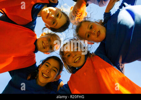 Portrait girls soccer team in huddle Stock Photo