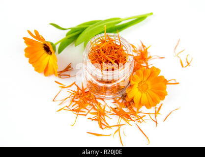 Dried Calendula officinalis the pot marigold, ruddles, common marigold or Scotch marigold, plant blossom petals in transparent clear glass jar with f Stock Photo