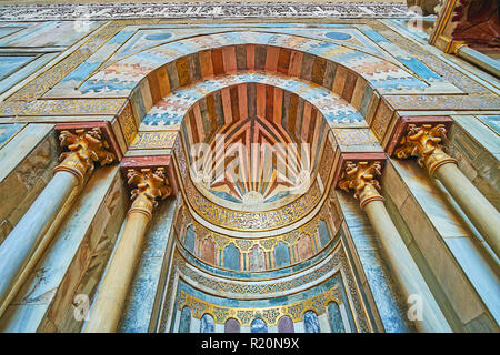 CAIRO, EGYPT - DECEMBER 21, 2017: The close-up of the medieval mihrab of Sultan Hassan Mosque-Madrasa, decorated with pillars, golden Arabic calligrap Stock Photo