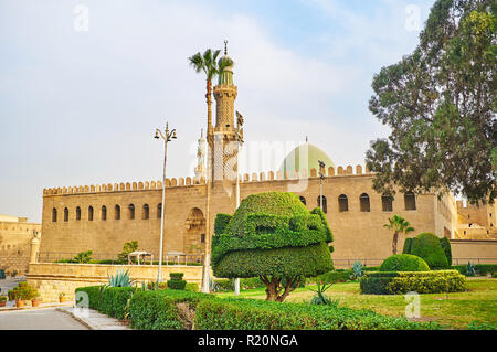 Relax in ornamental garden of Saladin Citadel with a view on medieval Al-Nasir Muhammad Mosque, Cairo, Egypt. Stock Photo