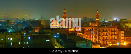 The foggy evening in Islamic Cairo with a view on medieval minarets and domes of Sultan Qalawun, Al Moez and Elzaher Barqooq Mosques, Egypt. Stock Photo