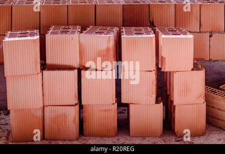 Brick wall with a stack of new bricks, some broken Stock Photo