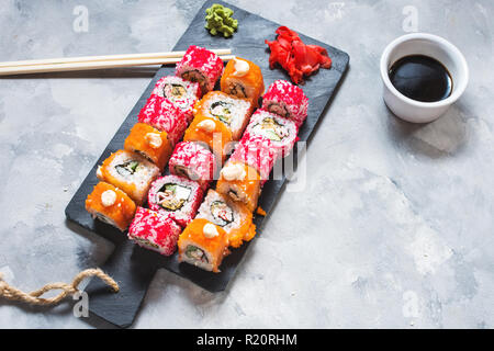 Assorted sushi rolls set served on plate on concrete background Stock Photo