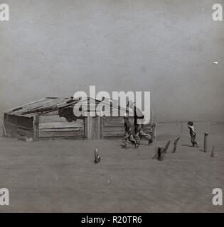 Photograph of a farmer and son walking in the face of a dust storm in Cimarron County, Oklahoma. Photograph taken by Arthur Rothstein (1915-1985). Stock Photo