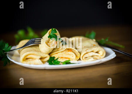 thin fried pancakes stuffed with stewed cabbage in a plate Stock Photo