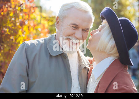 Nice aged woman kissing her beloved husband Stock Photo