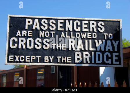 Railway sign stating that passengers are not allowed to cross the railway except by the bridge, England Stock Photo