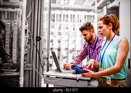 Technicians using laptop while analyzing server Stock Photo