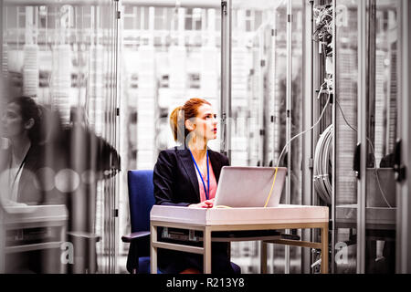 Technician using laptop while analyzing server Stock Photo