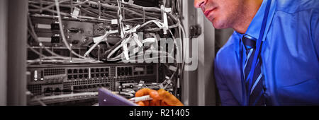 Technician maintaining record of rack mounted server on clipboard Stock Photo