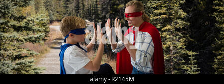 Composite image of mother and son pretending to be superhero Stock Photo