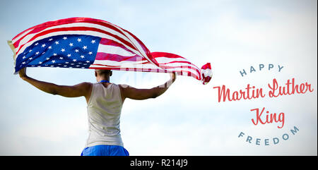 Composite image of rear view of sportsman holding american flag Stock Photo