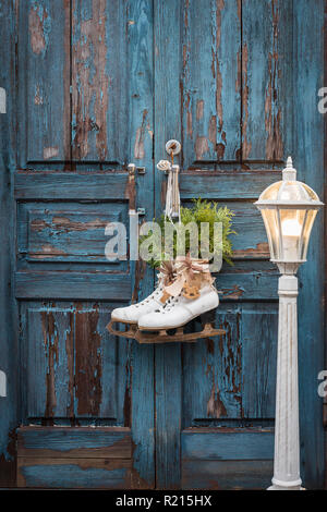 Pair of white women's ice skates on white and blue vintage