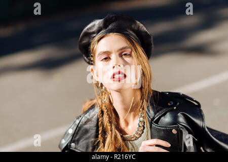 Skinny photo model wearing stylish black leather cap and jacket Stock Photo