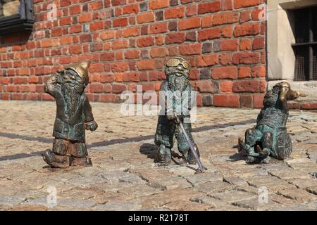 WROCLAW, POLAND - SEPTEMBER 2, 2018: Disabled gnomes or dwarves bronze statuette in Wroclaw, Poland. Wroclaw has 350 gnome sculptures around the city. Stock Photo
