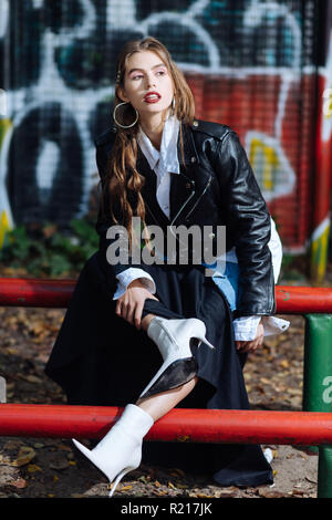 Stylish trendy fashionable model wearing long skirt posing at the stadium Stock Photo