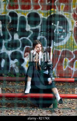 Trendy skinny model wearing fashionable outfit posing at the stadium Stock Photo