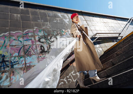 Stylish skinny fashion model posing wearing beige coat and red beret Stock Photo