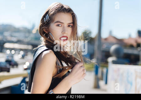 Close up of charming beautiful dark-eyed model wearing silver earrings Stock Photo