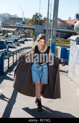 Stylish fashion blogger wearing denim shorts and baggy coat Stock Photo