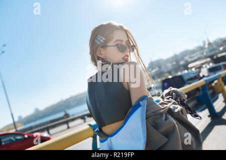 Stylish fashion blogger wearing open shoulder leather top Stock Photo
