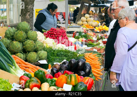 St-Cyprien, Dordogne, France - 24th September 2015: Shoppers examine the colourful fruit and vegetables displayed during the Sunday street market in St-Cyprien, Dordogne, France Stock Photo