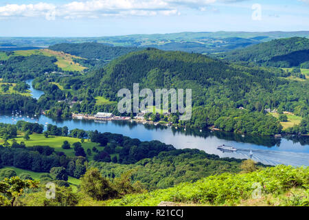 The view over south end of Lake Windermere from the path to Gummers How on a beautiful summer morning. A passenger ferry arrives at Lakeside pier. Gummers How is a well known viewpoint in The Lake District, Cumbria, UK. Stock Photo