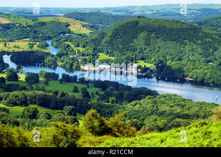 The view over south end of Lake Windermere from the path to Gummers How on a beautiful summer morning. A passenger ferry arrives at Lakeside pier. Gummers How is a well known viewpoint in The Lake District, Cumbria, UK. Stock Photo