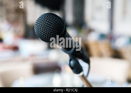 Close-up black iron microphone stands on the stage. Live music concert in a restaurant or bar in the evening Stock Photo