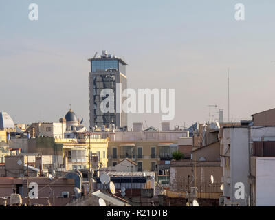 View over rooftops of older buildings in Barcelona, Spain, with the modern  Smart Flats, Passeig De Gracia  Apartment Hotel building in the background. Stock Photo