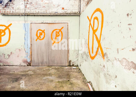 Hand painted no parking signs. A capital P in circles with a diagonal line through them. Painted on walls and doors in Consett, County Durham, UK Stock Photo