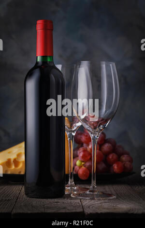 Bottle of red wine and two empty glasses close-up on a wooden table. Still life with alcohol Stock Photo