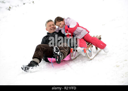 Father and daughter sledging in Shropshire Stock Photo