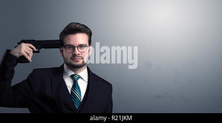 Young lost businessman man shooting his head with gun Stock Photo